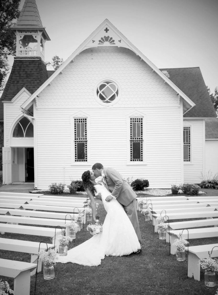 Bride and groom kissing in front of historic chapel